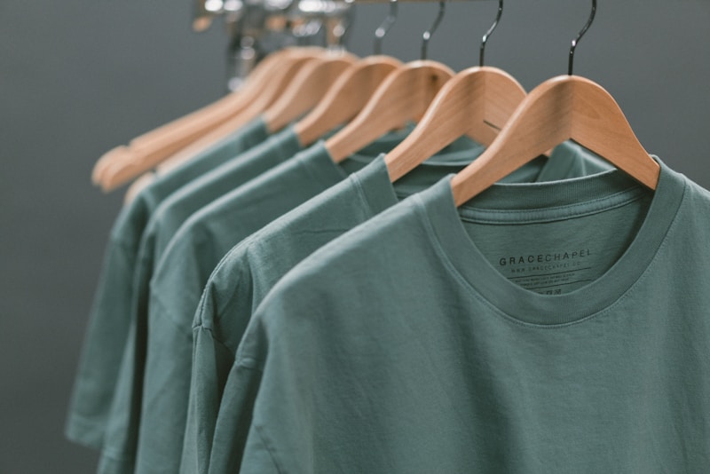 Green cotton T-shirts on hangers