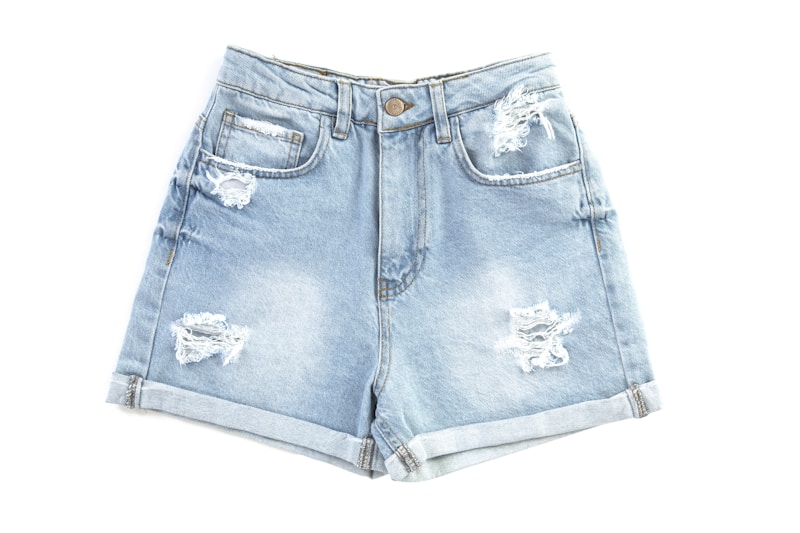 Light blue denim shorts front view on white